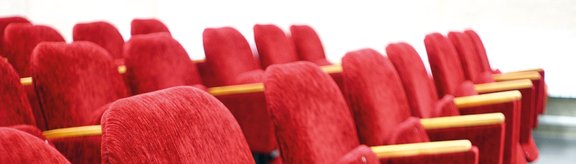 Reihen von roten Stühlen in einem Kino