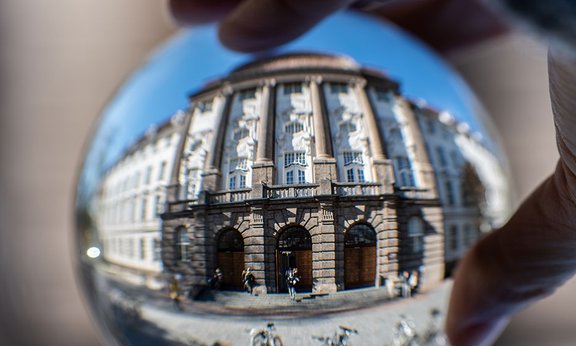 Hauptgebäude der Universität Innsbruck, in einer Glaskugel gespiegelt