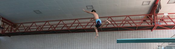 Kind springt vom Turm ins Wasser