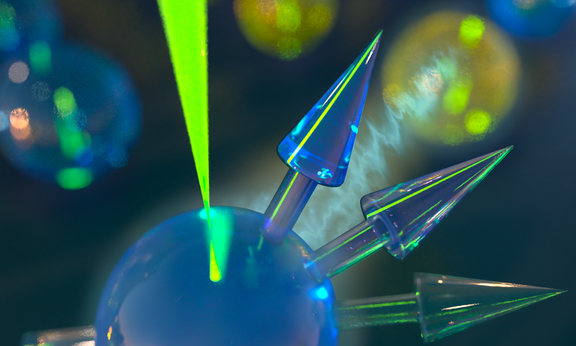 Ein intensiver Laserstrahl strahlt auf eine Kugel und hebt deren Form durch Lichtkontraste hervor