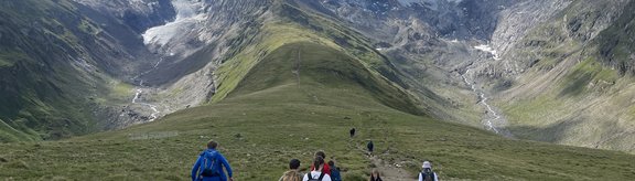Eine Gruppe von Jugend­li­chen wan­dern in den Tiro­ler Ber­gen.