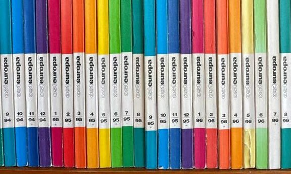 Bücher in einem Regal in Regenbogenfarben
