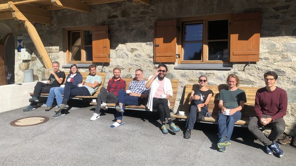 DiSC-Mitglieder sitzen auf einer Bank in der Sonne