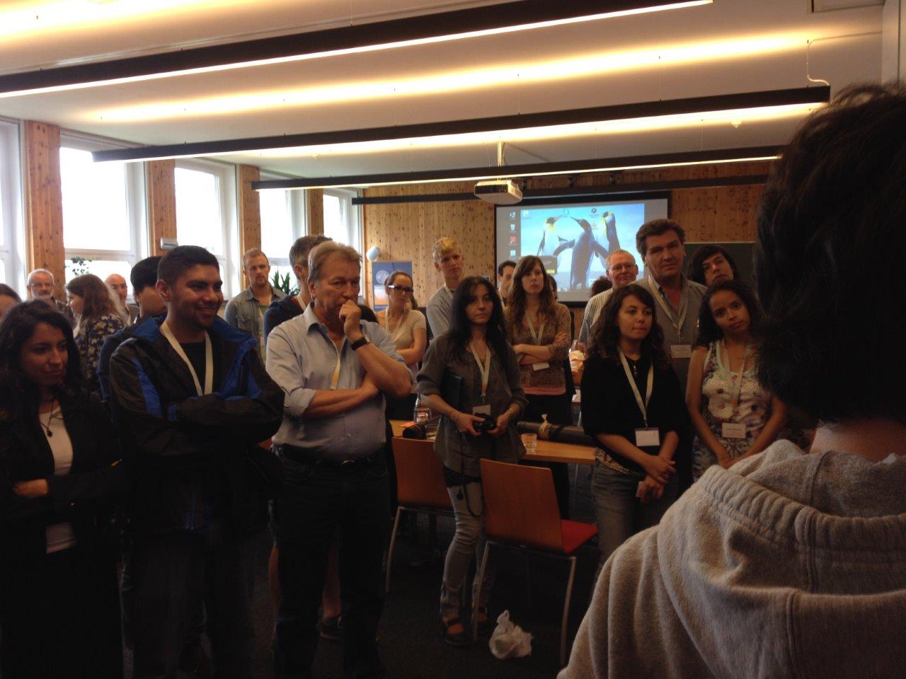 Participants listen to thesis presentations