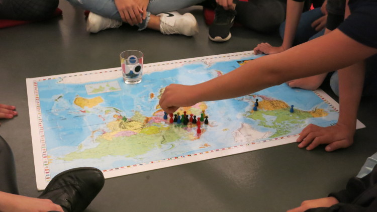 Eine Figur wird auf der Weltkarte abgelegt