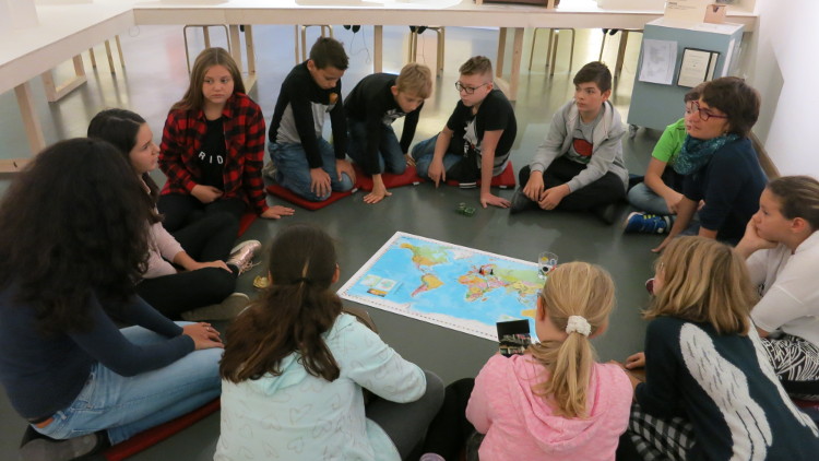 Die Gruppe schaut sich die Weltkarte an