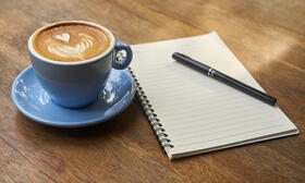 Kaffeetasse und Notizblock