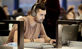 student with headset on laptop