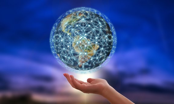 Über einer Hand schwebt eine Weltkugel, die von einem Netzwerk umspannt wird