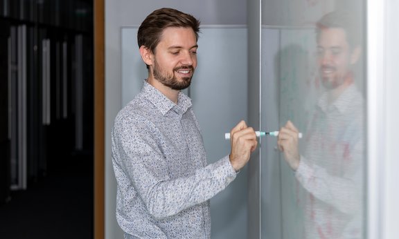 Torsten Zache zeichnet mit einem Stift etwas auf ein Whiteboard