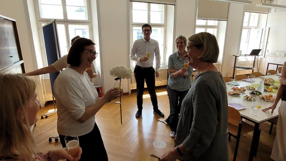 Zu sehen sind die Mitglieder des Instituts beim Sommerumtrunk. Blumen werden überreicht.