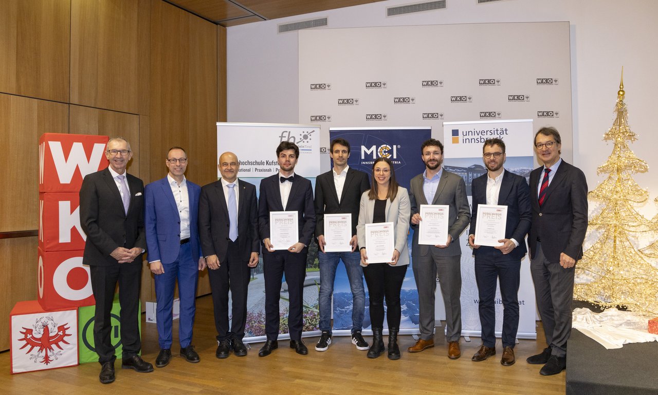 Preisträgerinnen und Preisträger stehen für ein Gruppenbild zusammen.