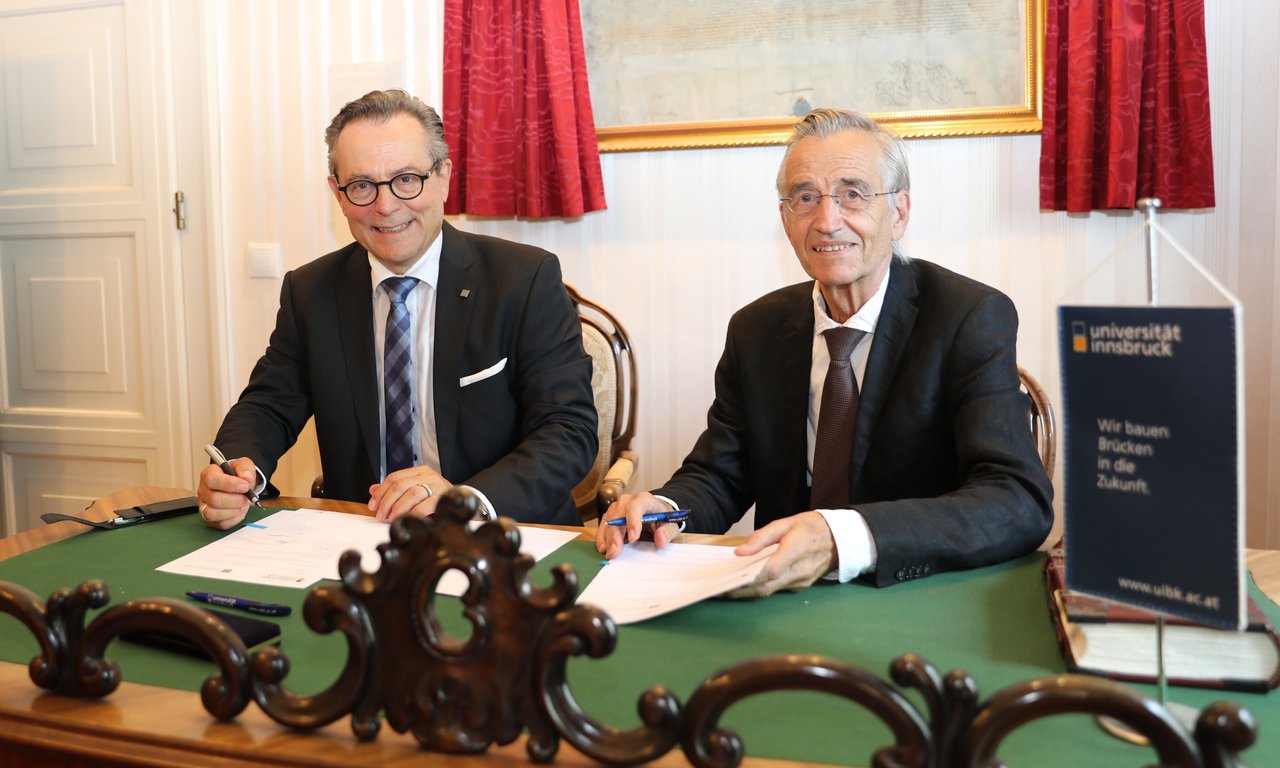 Jürg Kessler, Rektor der FH Graubünden und Tilmann Märk, Rektor der Universität Innsbruck bei der Unterzeichnung des Kooperationsvertrags im Salon des Rektors an der Universität Innsbruck.