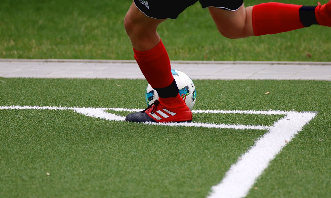 A soccer player performing a corner kick