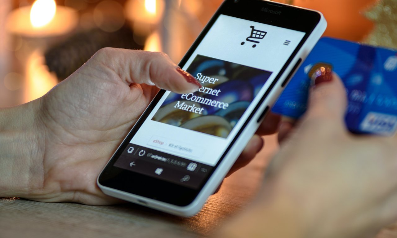 Symbolbild: Smartphone in der Hand einer Person, auf dem Bildschirm ist eine Einkaufswebsite zu sehen.