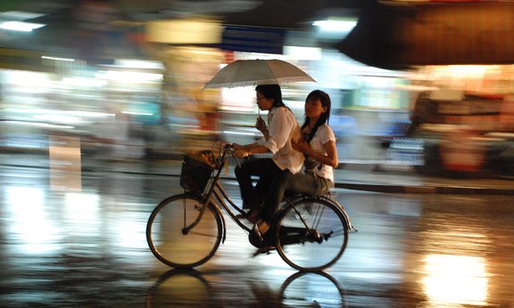 Radfahrerinnen im Regen in Hanoi