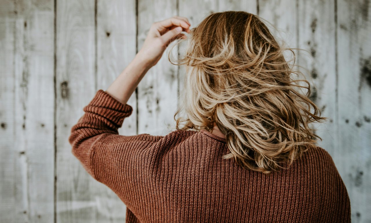 Blick auf die langen, offenen Haare einer Person von hinten