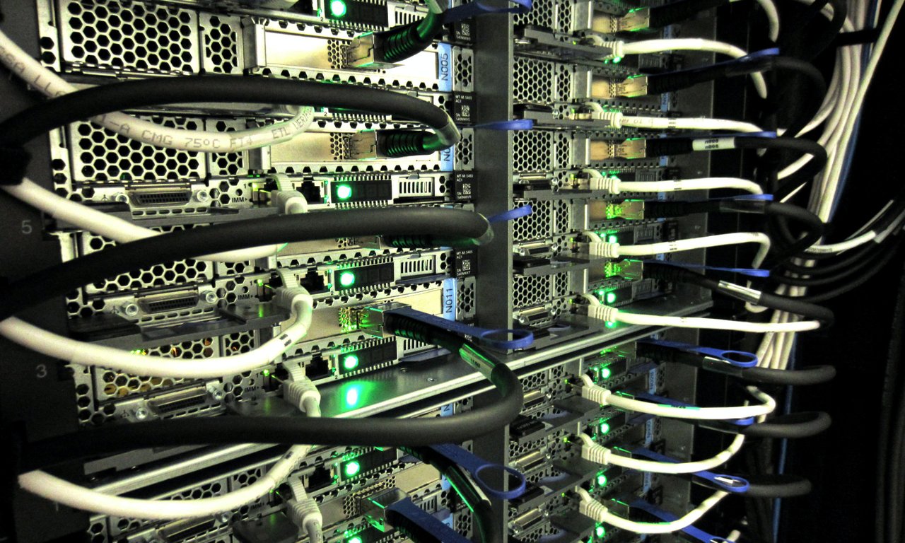 Die Rückseite eines Hochleistungscomputers mit Kabeln und grün leuchtenden Lampen