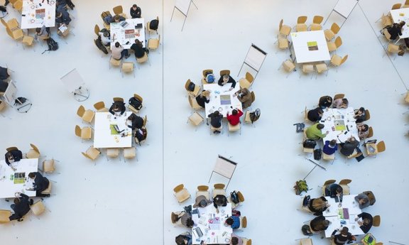 Mehrere Tische mit Personen ringsum aus der Vogelperspektive