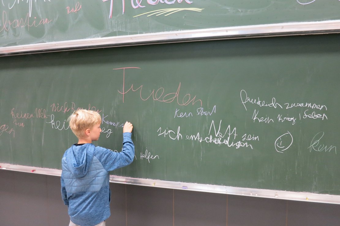 Ein Kind schreibt auf einer Tafel