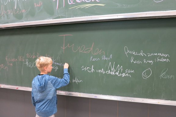 Ein Kind schreibt auf einer Tafel