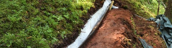 A ground slot dug out lengthwise to the slope, approx. 5 metres long, covered with a film and with a rain gutter above it to collect water.