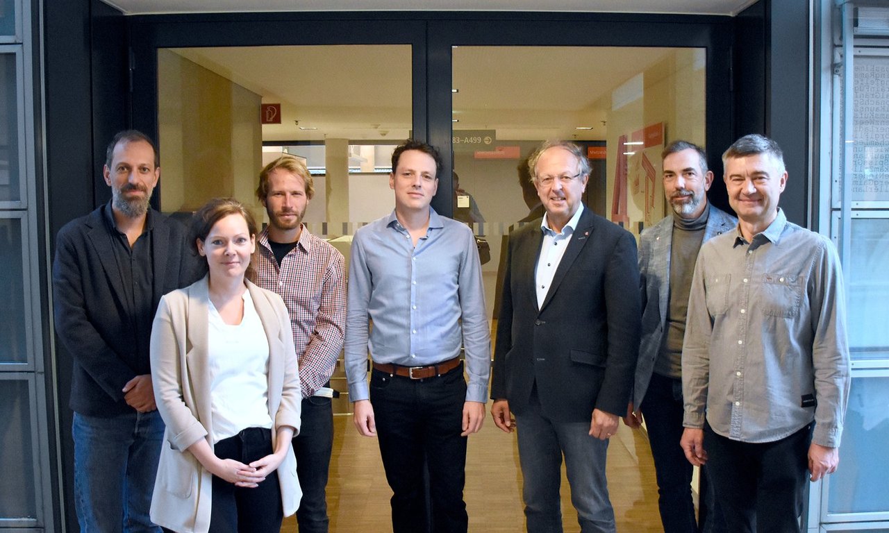 Gruppenbild der Projektbeteiligten vor einer Glastür