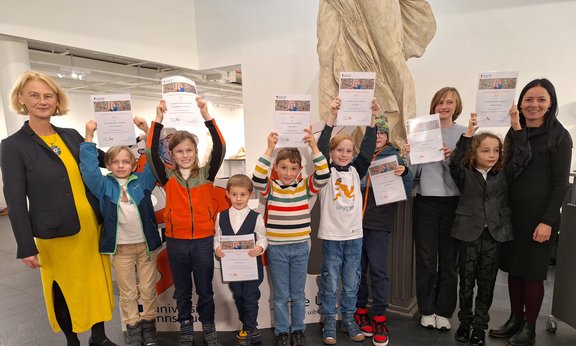 Kinder halten das Diplom in ihre Hände.