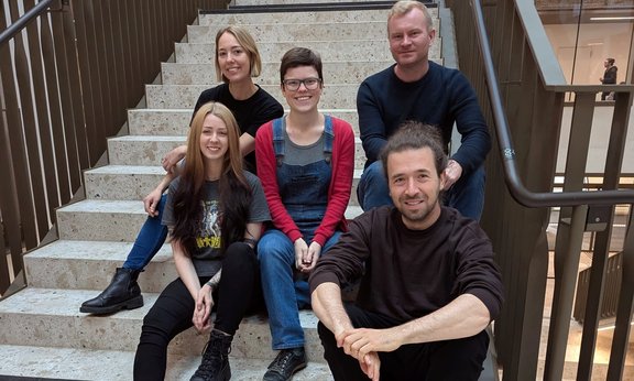 5 Projektmitglieder sitzend auf den Stufen des Agnes Heller Hauses