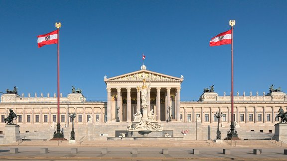 Blick auf die Fassade des beflaggten Parlamentsgebäudes von der Ringstraßenseite