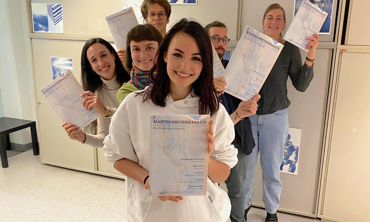 Das Team steht in einer Reihe und jeder hält ein Exemplar des Magazins in der Hand.