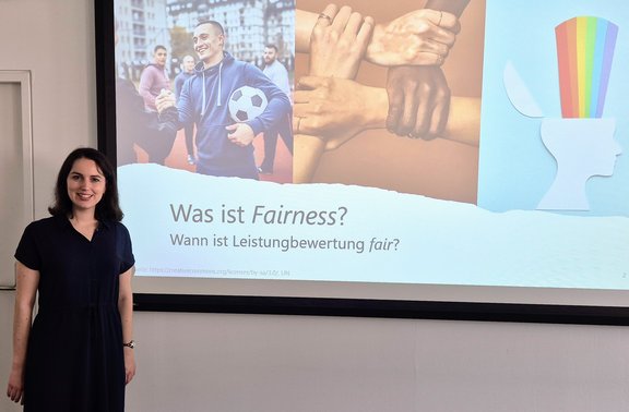 Elisa Guggenbichler in front of screen, presenting on Fairness in Language Assessment