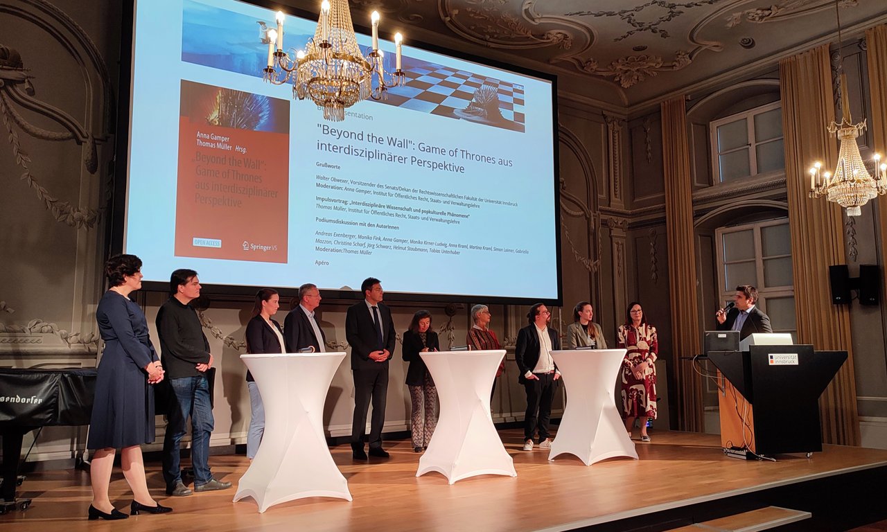 Elf Personen auf der Bühne im Kaiser-Leopold-Saal für eine Podiumsdiskussion