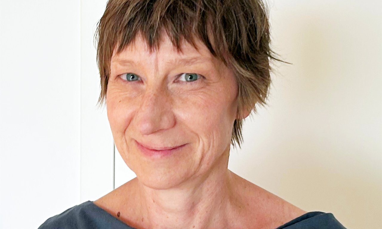 Porträtfoto von Kathrin Breuker vor weißem Hintergrund