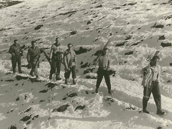 Archivbild, Personen tragen Holzski auf den Schultern