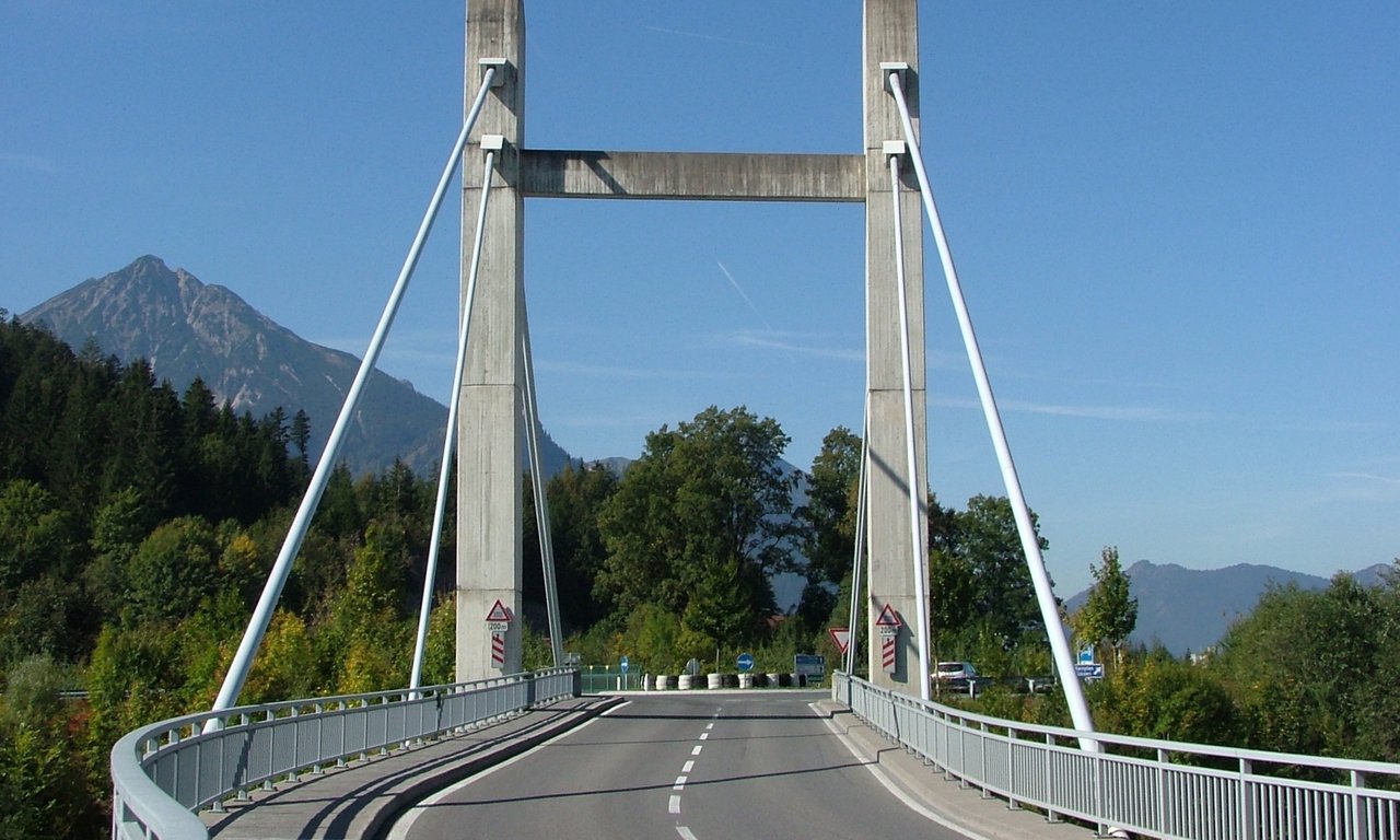 Blick auf die beiden Stützen einer Hängebrücke von der Fahrbahn aus.