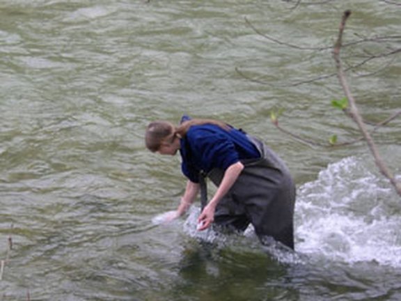 Eine Person steht in einem Fluss, um Messungen durchzuführen