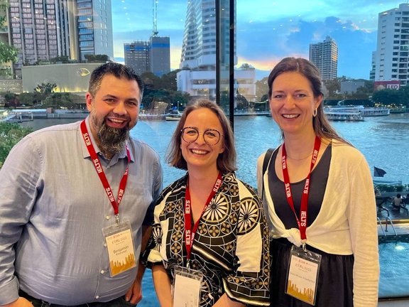 Benjamin Kremmel, Kathrin Eberharter & Doris Moser-Frötscher in front of window with view on Bangkok river & skyline