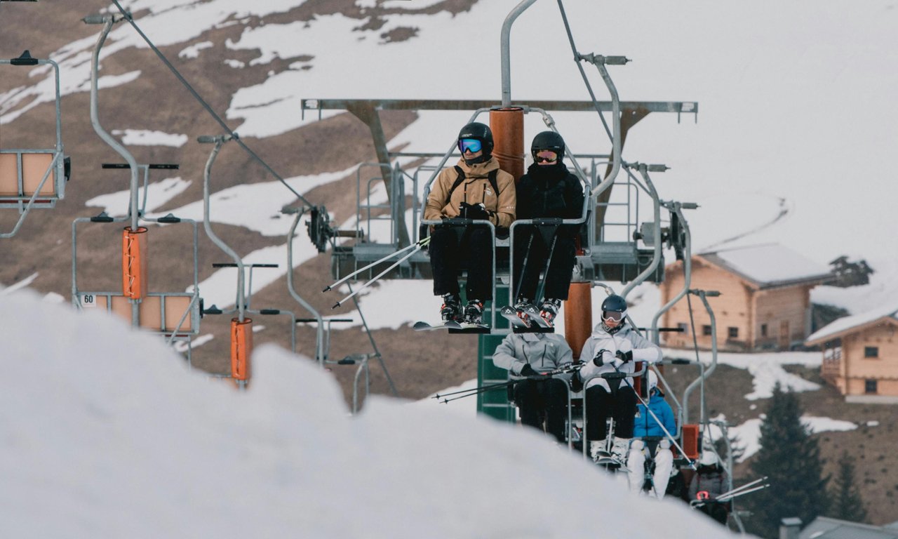 Zwei Skifahrer sitzen im Sessellift