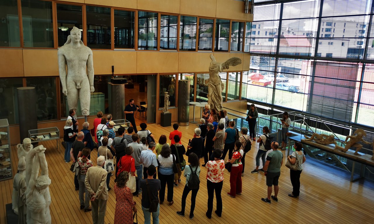 Ein Vortrag vor Besucher*innen vor Statuen des archäologischen Museums