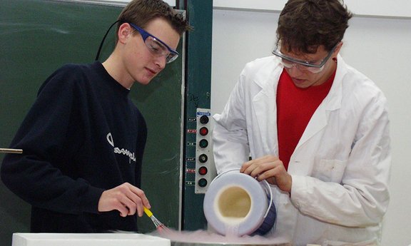 Darstellung von zwei Schülern bei einem Experiment