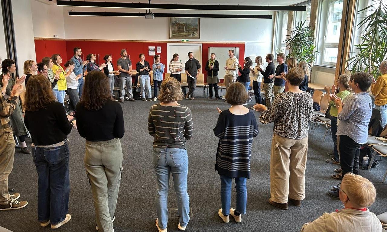 Teilnehmer:innen der Veranstaltung stehen im Kreis