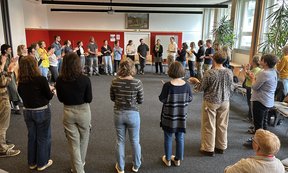 Teilnehmer:innen der Veranstaltung stehen im Kreis