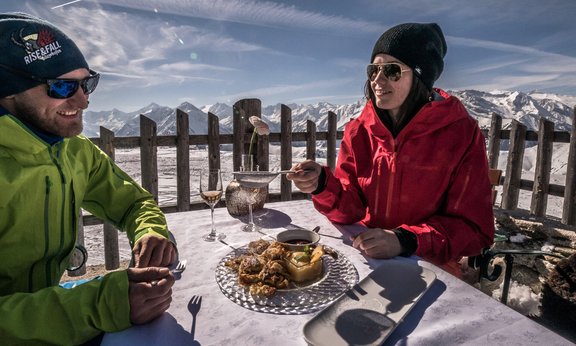 Paar beim Essen auf einer Alm im Winter