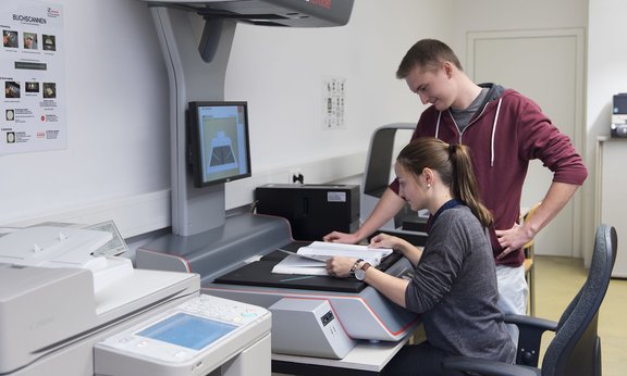 Studierende arbeiten am Scanner in der Hauptbibliothek