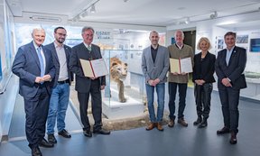 Gruppenfoto mit Preisträgern und Modell von Höhlenlöwen in der Mitte