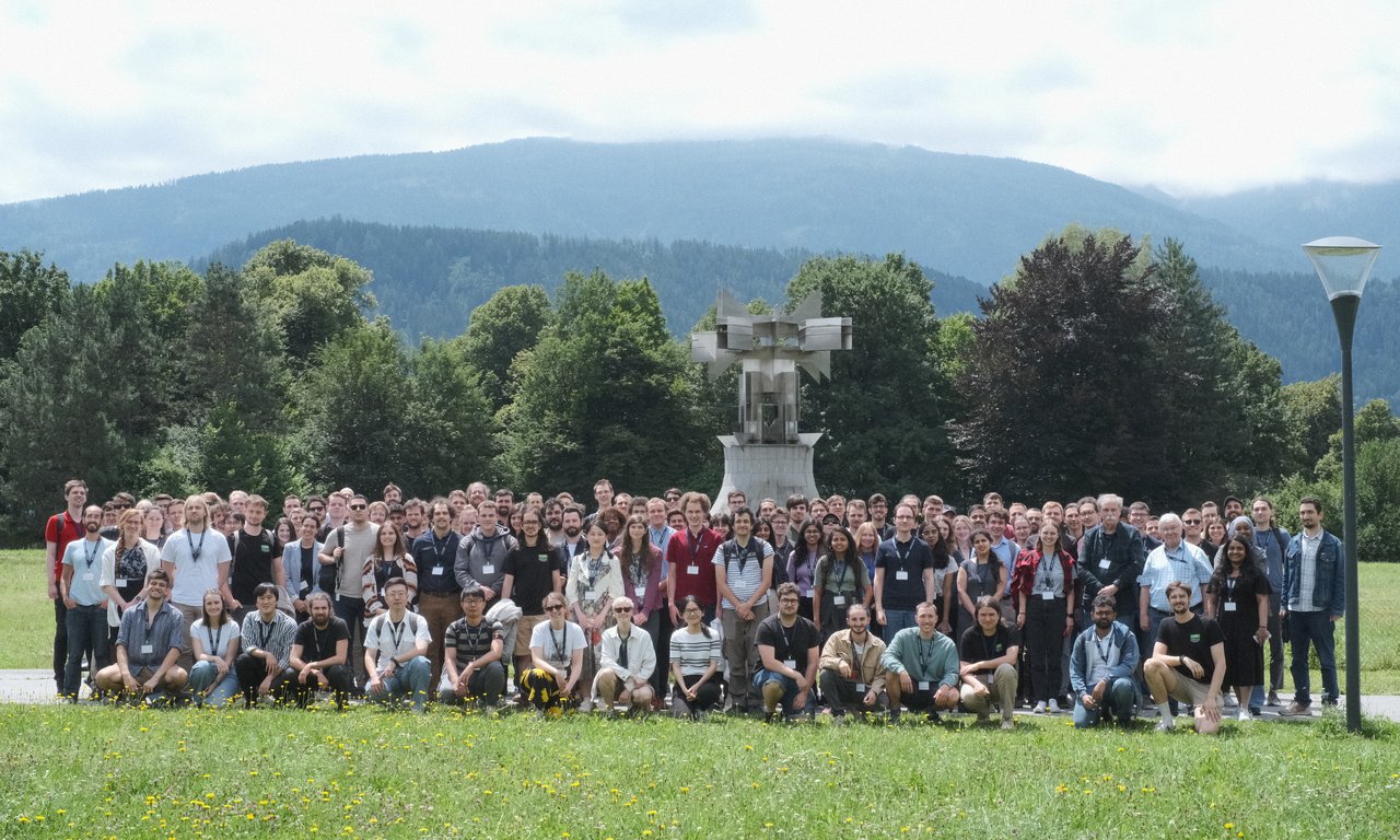 Großes Gruppenfoto im Freien, Bäume im Hintergrund.