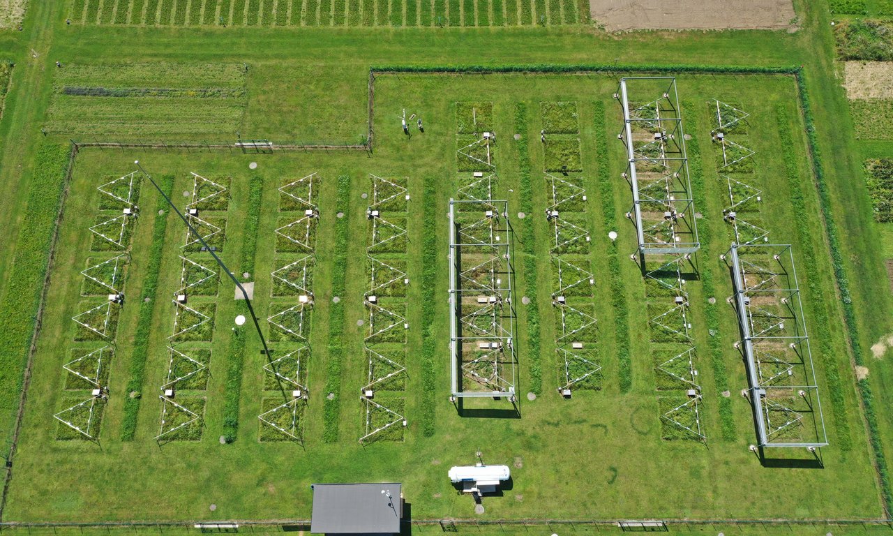 Aerial view of a green grassland with various metal elements arranged in parcels.