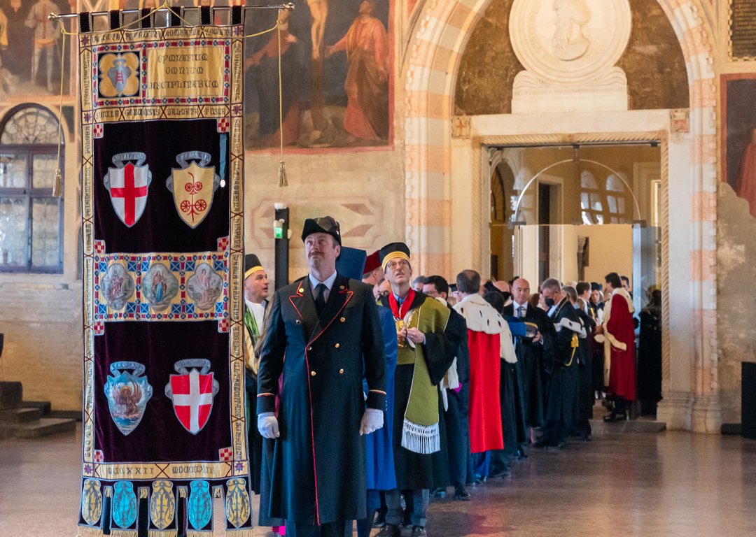 Festlich gekleidete Menschen tragen Wappen der Universität Padua