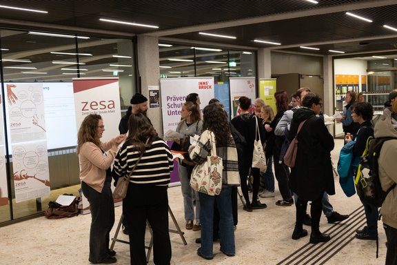 Dynamisches Bild von verschiedenen Studierenden, die sich bei Tischen informieren.